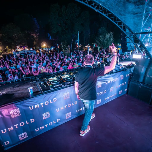 Tim Clark on stage at UNTOLD festival, arm raised to the crowd